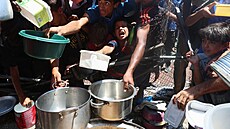 Palestinci, kte�í trpí hladem, se shroma��ují u výdeje jídla z charitativní...