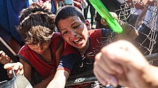 Palestinci, kteí trpí hladem, se shromaují u výdeje jídla z charitativní...