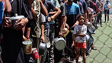 Palestinci, kte�í trpí hladem, se shroma��ují u výdeje jídla z charitativní...