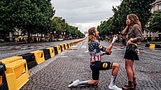 Americký cyklista Quinn Simmons ádá pítelkyni o ruku po poslední etap Tour...