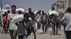 Palestinci si rozebírají pomoc p�ivezenou kamiony do Gazy. (27. �ervence 2025)