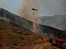 lenové záchranných slueb a místní obyvatelé se snaí uhasit lesní poár...
