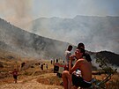 lenové záchranných slueb a místní obyvatelé se snaí uhasit lesní poár...