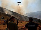 lenové záchranných slueb a místní obyvatelé se snaí uhasit lesní poár...