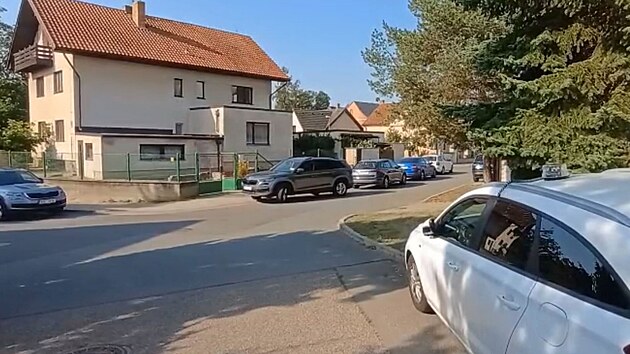 Policejn auta ped domem v praskch Kunraticch, kde se mla stt vrada. (15. srpna 2025)