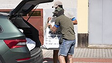 Kriminalisté z bytu dárce bitcoin Tomáe Jiikovského odnáejí pytle s dkazy....