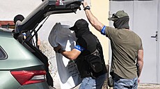 Kriminalisté z bytu dárce bitcoin Tomáe Jiikovského odnáejí pytle s dkazy....