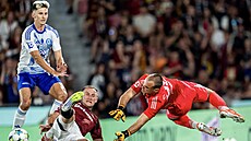 Spar�anský úto�ník Jan Kuchta se ve skluzu sna�í dostat k balonu v utkání s...