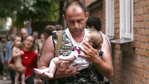 Ruský policista Elbrus Gogni�ajev vyná�í ze �koly v Beslanu malou Aljonu...