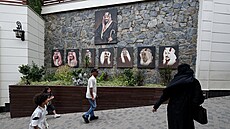 Návtvníci procházejí kolem obraz saúdské královské rodiny pi píjezdu do...