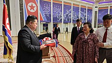 Kim ong-un v Pchjongjangu pedává portrét zabalený v severokorejské vlajce...