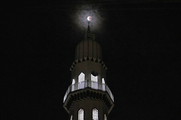 ��ste�n� zakryt� M�s�c st�nem Zem� je vid�t p�es minaret me�ity v Rawalpindi v...