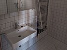 Koupelna s umyvadlem a sprchovm koutem v jednom z pokoj pro ubytovn v...