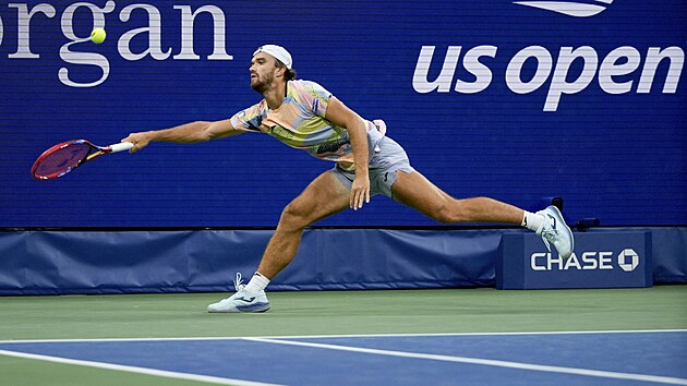 Tomáš Macháč se natahuje po míčku v osmifinále US Open.