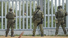 Bloruský pohraniní stráce je vidt za plotem ped návtvou polského...