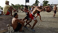 Filipínci hrají basketbal v rybá�ské vesnici v oblasti slumu Baseco v Manile....
