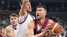 Kristaps Porzingis z Lotyska (vpravo) zakonuje pes Marina Peterku.