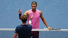 Ji�í Lehe�ka (zády) a Carlos Alcaraz si podávají ruce po �tvrtfinále US Open.
