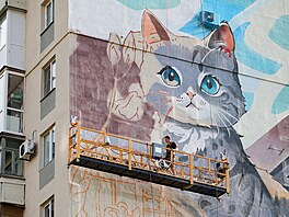 Um�lec maluje nást�nnou malbu na bytovém dom�  v okupovaném Mariupolu. (7....