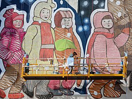 Um�lec maluje nást�nnou malbu na bytovém dom� v okupovaném Mariupolu. (7....