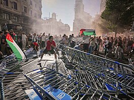 Propalestintí aktivisté demolují bariéry, které mly zajistit bezpený prjezd...