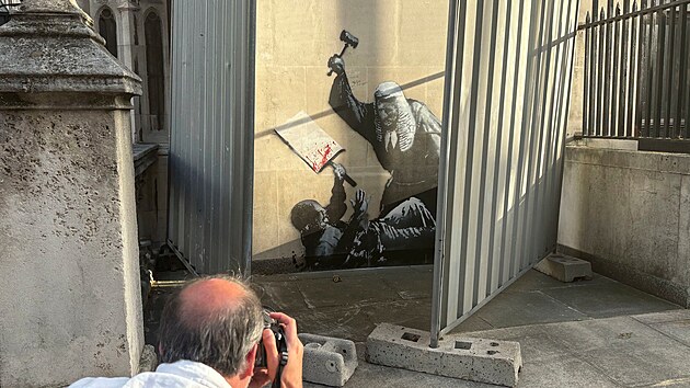 Um�lec vystupuj�c� pod jm�nem Banksy odhalil nov� d�lo na budov� lond�nsk�ho soudu, nedlouho pot� ale v�tvor zakryly z�brany. (8. z��� 2025)