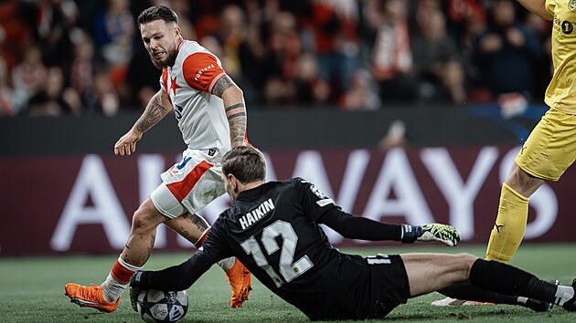 Branká� Bödo/Glimt Nikita Haikin chytá balon p�ed slávistickým Vasilem Ku�ejem...