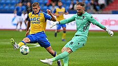 Dominik Holec odkopává mí� p�ed dotírajícím Jehorem Cykalem.