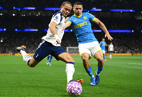 Záloník Xavi Simons z Tottenhamu (vlevo) se snaí odcentrovat pes Andrého z...