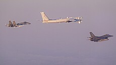 Americký letoun F-16 Fighting Falcon (vpravo) eskortuje ruský bombardér Tu-95...