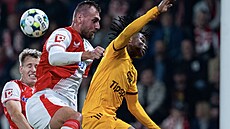 Slávisté Zmrzlý a Chorý (zleva) v hlavikovém souboji s Isifem z Dukly.