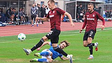 Ostravský obránce Alexander Munksgaard se skluzem snaí odkopnout mí ped...