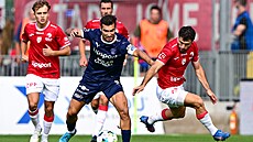 Záloník Michal Trávník ze Slovácka se snaí prosadit kolem bránícího...