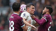 Útoník Chris Wood z Nottinghamu v tuhém stetu s forvardem Jaidonem Anthonym z...