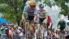 Remco Evenepoel z Belgie se bhem závodu MS ve Rwand obrací na Jaie Hindleyho...