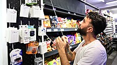 Prodava� z mnichovského kiosku Sina Shop na Schellingstrasse zatahuje roletu u...