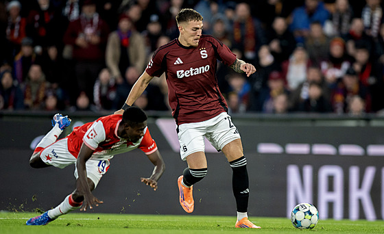 Sparanský záloník Patrik Vydra pechází s míem pes Oscara ze Slavie.