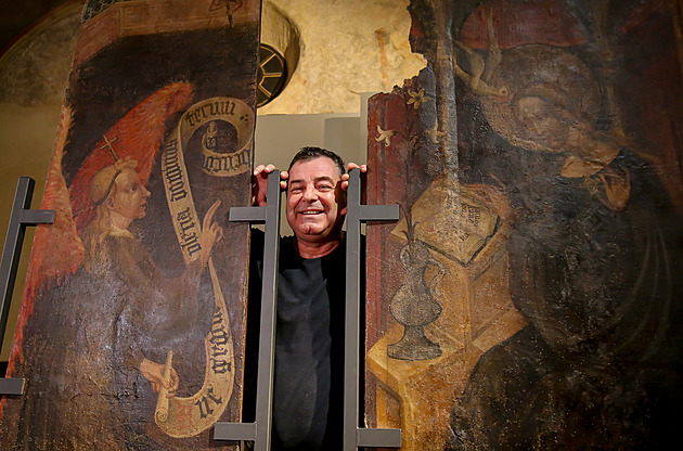 Restaurtor Miroslav Koeluh pzuje fotografm u hotovho dla, dvou oltnch gotickch desek.