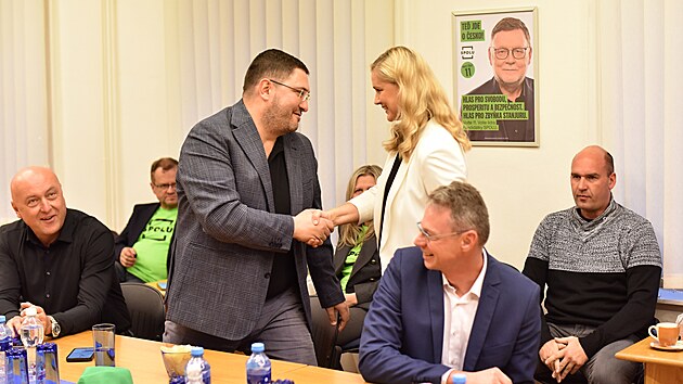 Nov poslanci SPOLU, starostka Krava a bval Miss Evropy Monika dkov Brzeskov a nmstek Havova Bohuslav Niemiec (oba KDU-SL), si navzjem blahopej k volebnmu vsledku. Ldr Zbynk Stanjura (vzadu na plaktu) se propadl a na pt msto. (4. jna 2025)