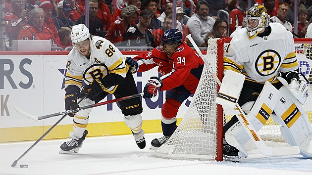 David Pastrk (88) z Boston Bruins za brnou svho glmana Jeremyho Swaymana, tla na nj Justin Sourdif (34) z Washington Capitals.