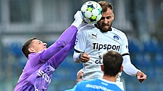 Mladoboleslavský branká Jií Floder boxuje mí ped anem Medvedem ze Slovácka.