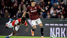 Sparanský záloník Patrik Vydra pechází s míem pes Oscara ze Slavie.