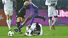 Záloník Nelson Okeke z Bohemians fauluje ped zraky hlavního rozhodího Lukáe...