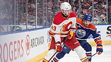Adam Klapka z Calgary u puku v zápase s Edmontonem, brání ho Matt Savoie.