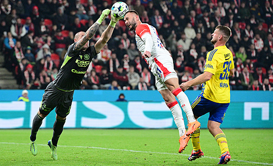 Zlínský branká Stanislav Dostál vyráí mí ped Erikem Prekopem ze Slavie.
