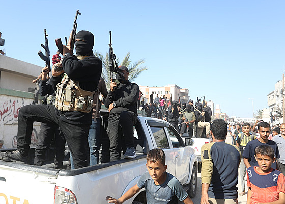 �lenové palestinského teroristického hnutí Hamás doprovázejí vozidla �erveného...