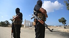 Palestintí ozbrojenci v Pásmu Gazy stojí na strái, zatímco vozidla erveného...