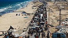 Vysídlení Palestinci jedou na nákladních vozech naloených svými vcmi a mávají...