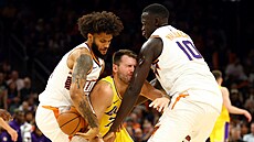 Luka Doni z Los Angeles Lakers se snaí prosmýknout mezi bránící dvojicí...