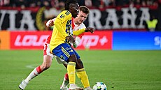 Zlínský útoník Stanley Kanu hraje s míem ped tpánem Chaloupkem ze Slavie.